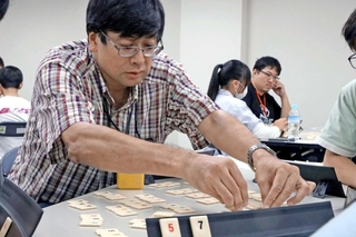 真剣な面持ちでタイルを並べる参加者＝加古川市加古川町溝之口
