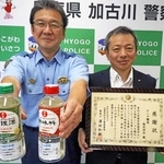 啓発メッセージを付けた調味料を配り、署長感謝状を受けたキング醸造の青木延恭取締役（右）＝加古川署