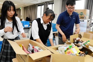 集まった食品を仕分ける手伝いをする松陽高校の生徒ら＝高砂市松陽１