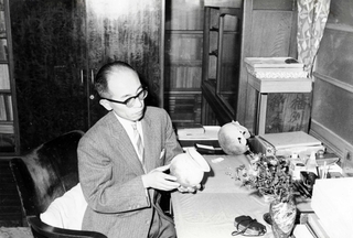 土器を手にする今里幾次氏＝昭和３６年、自宅にて