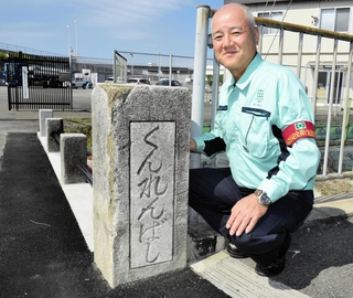 「ばし」が地上に現れた史跡「訓練橋」の親柱に、笑顔を見せるハリマ化成の藤本恵弘生産本部長＝加古川市野口町野口