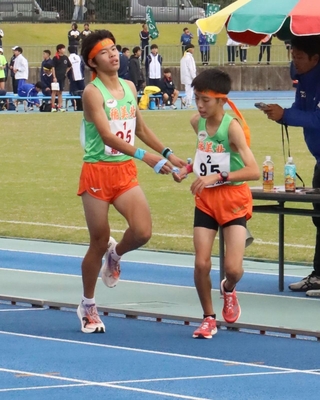 男子・稲美北の１区中川悠聖選手からたすきを受ける２区藤井陽生選手（右）＝ＳＨＯＷＡグループ陸上競技場