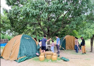 芝生広場で開催された防災キャンプ。雨の心配があり、木陰にテントを設営した（提供）