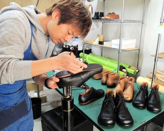 長く履き続ける革靴を製作する滝本武さん。新製品（右）は修理を前提とした構造も特徴という＝加古川市尾上町池田