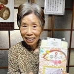 敬老の日に児童館の子どものメッセージを受け取り、喜ぶ訪問介護利用の女性＝加古川市志方町（鶴林園提供）