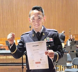 コンクールの賞状を手に笑顔を浮かべる柴田昌宜さん＝ワルシャワ（柴田さん提供）