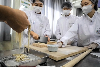 麺を切る学生＝兵庫大