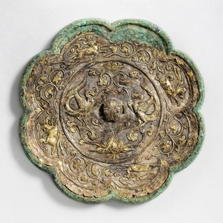 向かい合う鳳凰。「貼銀鍍金（ちょうぎんときん）双鳳走獣紋八稜鏡」（古代鏡展示館所蔵）