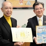 紙芝居「工楽松右衛門物語」を元に絵本を作って高砂市に寄贈した「ルネサンスみなと町高砂」の新井哲三会長（左）＝高砂市役所