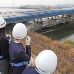 高所作業車から工事中の加古川橋を見下ろす加古川小の児童ら＝加古川市加古川町本町