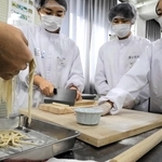 麺を切る学生＝兵庫大