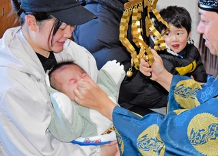 鼻をつまむ神事で元気よく泣き声を上げる男児＝高砂市北浜町西浜