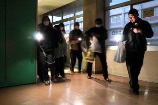 地震による停電を想定し、スマートフォンや懐中電灯の明かりで避難する生徒や地域住民ら＝高砂市曽根町