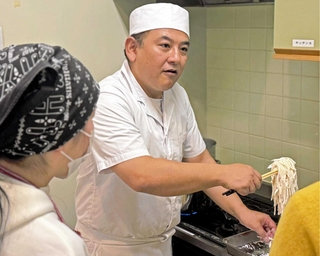参加者においしいうどんの作り方を伝授する丸亀製麺の木村成克さん（中央）＝加古川総合文化センター