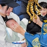 鼻をつまむ神事で元気よく泣き声を上げる男児＝高砂市北浜町西浜