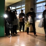 地震による停電を想定し、スマートフォンや懐中電灯の明かりで避難する生徒や地域住民ら＝高砂市曽根町