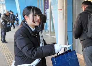 通行人に投票を呼びかける啓発グッズを配る加古川西高の生徒＝ＪＲ加古川駅前