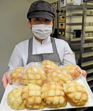 「サクッ、フワッ、もっちりが人気の秘密」と焼き上がったメロンパンをアピールする西岡裕理さん＝加古川市神野町神野