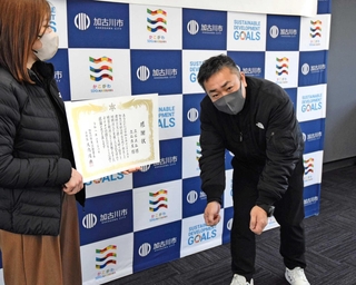 火元のファンヒーターを持ち出す場面を再現する立石正弘さん（右）＝加古川市東消防署