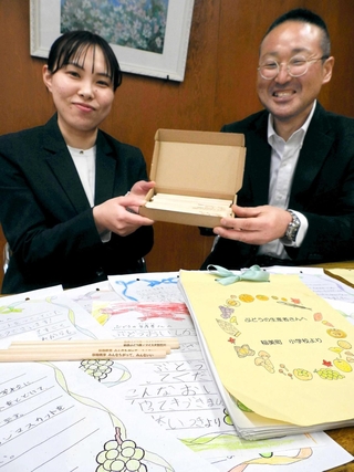 子どもたちの手紙と、返礼の鉛筆を前に話すブドウ農家の前原芳幸さん（右）と栄養教諭の川崎陽さん＝稲美町岡、天満東小学校