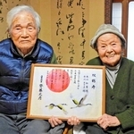 そろっての長寿を祝う「双鶴寿」と書かれた兵庫県からの祝い状を手にする本川和雄さん、きさゑさん＝稲美町中一色