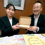 子どもたちの手紙と、返礼の鉛筆を前に話すブドウ農家の前原芳幸さん（右）と栄養教諭の川崎陽さん＝稲美町岡、天満東小学校