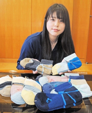 加古川の職人の技が生かされたＬ字型靴下をアピールする「ホリホック」の社員＝加古川市神野町西条