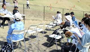 犬連れの人たちに、ペットとの同行避難への備えについて話す永井達也さん（左奥）＝加古川市上荘町見土呂