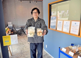 多目的スペースをオープンした西嶋輝さん。ラボ（右側）で地元素材のドーナツを作る＝加古川市加古川町新在家