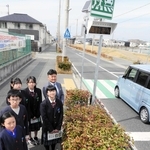 横断者サポート表示板と子ども議会で対策を求めた井口聡実さん（右手前）や播磨南小と播磨南中の児童、生徒ら＝播磨町古宮５