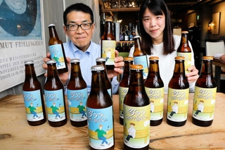 クラフトビールを販売する多木化学不動産事業部の社員。２種類のビールを並べるとラベルの人物が乾杯するようになる＝加古川市平岡町新在家２