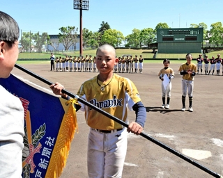 優勝旗を受け取る魚住フェニックスの選手＝日岡山公園野球場