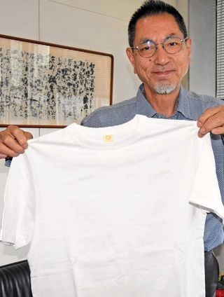 物々交換される播磨産綿のＴシャツを手に企画をアピールする鷲尾吉正さん＝加古川市加古川町