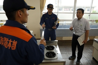 家庭科室でガスコンロの周りに燃える物がないのかチェックする加古川市消防本部の職員ら＝加古川小学校
