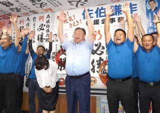 当選確実の知らせを受けて万歳する佐伯謙作氏（中央）＝播磨町西野添３