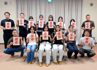 初開催の「志方夜市」のチラシを手にする高校生や実行委員会メンバー＝加古川市志方町（提供）