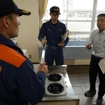 家庭科室でガスコンロの周りに燃える物がないのかチェックする加古川市消防本部の職員ら＝加古川小学校