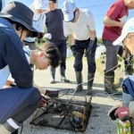 ため池の外来種を調べるため、住民とともに仕掛けたわなを回収する学生ら＝加古川市上荘町（ため池みらい研究所提供）