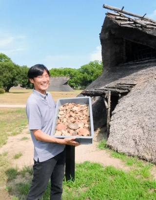 出土した土器のコンテナを持つ播磨町郷土資料館学芸員の大川康裕さん＝同町大中１、大中遺跡公園