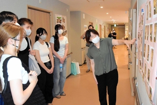 スタッフ（右）からグループホームでの季節イベントについて説明を受ける高校生ら＝加古川市別府町新野辺