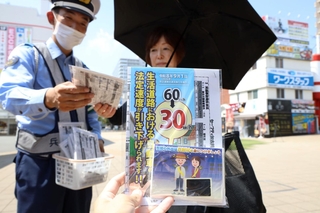 生活道路の法定速度が９月から引き下げられることを伝えるチラシなどを配った＝ＪＲ加古川駅前