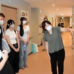 スタッフ（右）からグループホームでの季節イベントについて説明を受ける高校生ら＝加古川市別府町新野辺