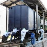 旧別府鉄道の貨車を押し進める作業員たち＝播磨町大中１