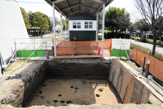 展示施設の改修に伴う発掘調査の現場。地下から多くの柱穴が見つかった。正面は旧別府鉄道の客車＝３月、播磨町大中１（同町郷土資料館提供）