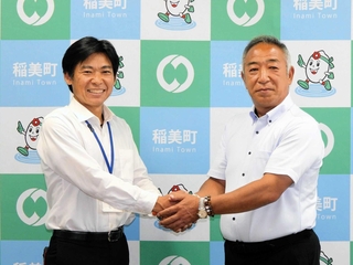 大学野球の国際大会優勝を報告し、握手する鈴木英之監督（右）と稲美町の中山哲郎町長＝同町役場