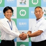 大学野球の国際大会優勝を報告し、握手する鈴木英之監督（右）と稲美町の中山哲郎町長＝同町役場