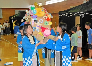 飾り付けられたみこしを担ぎ、会場を盛り上げた＝母里福祉会館
