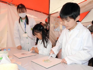 ワセリンを混ぜ、薬の調合を疑似体験する子どもたち＝加古川市加古川町北在家