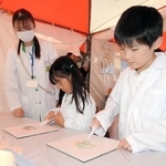 ワセリンを混ぜ、薬の調合を疑似体験する子どもたち＝加古川市加古川町北在家