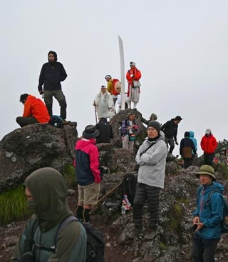 　解禁された男体山夜間登山に参加し、山頂で日の出を待つ登山者たち。この日、御来光は拝めなかった＝１日午前４時４５分ごろ、栃木県日光市